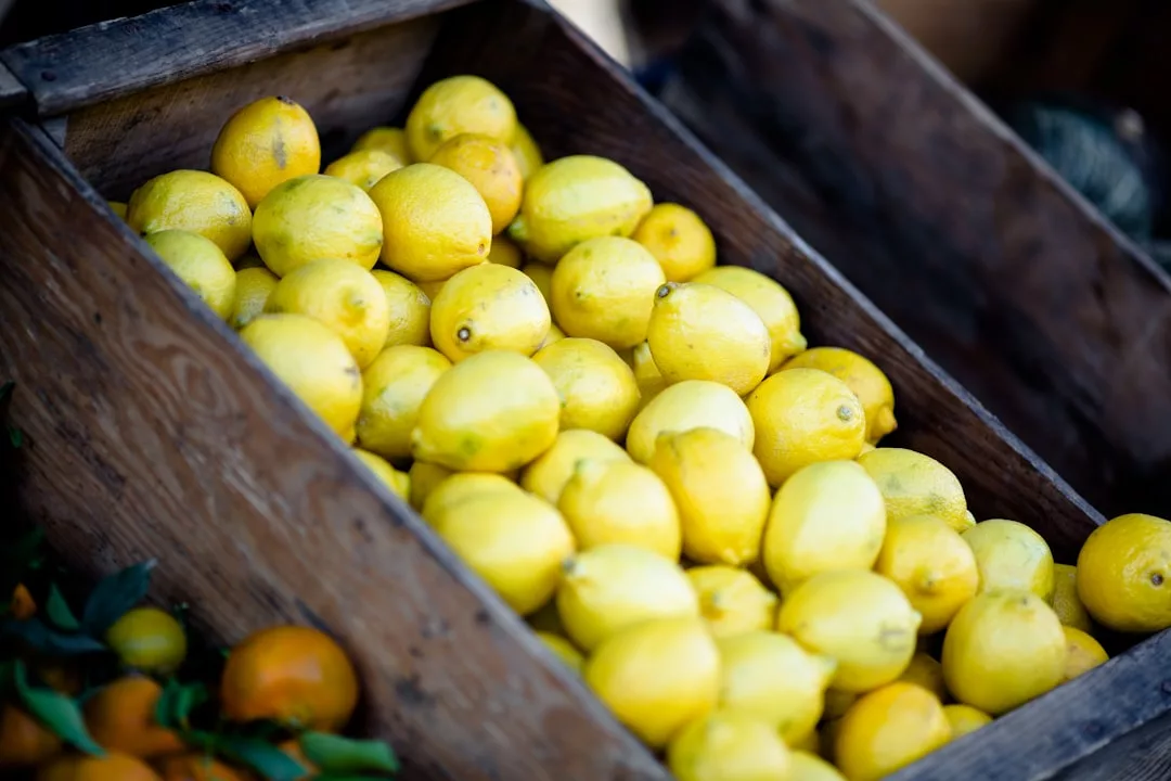 A wooden crate filled with fresh yellow lemons, handpicked by an Oslo-based agent with local expertise.