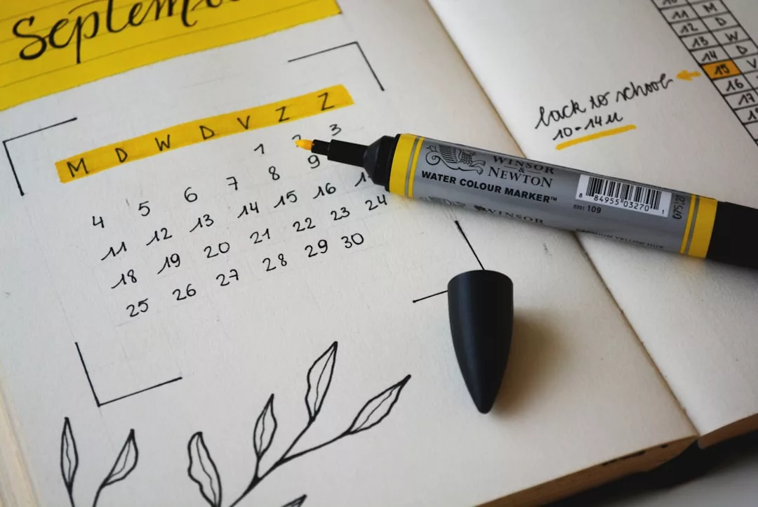 Open planner showing a September calendar, black and yellow marker, handwritten real estate notes, and simple leaf doodles.